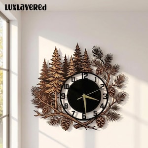 May include: A wall clock featuring a black circular face with white numbers and gold hands. The clock is surrounded by a brown wooden cutout design of pine trees, branches, and pinecones. The text LUXLAYERED is visible in the top corner.