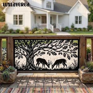 May include: A black metal decorative panel featuring a laser-cut design of a large oak tree with acorns and two deer grazing beneath the branches. The rectangular panel is mounted between two wooden posts on a porch with potted plants.