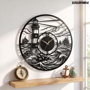 May include: A circular black wall clock featuring a cutout design of a lighthouse, crashing waves, and sailing ships. The clock face has a solid black center with gold-colored hands and numbers at the 3, 6, 9, and 12 positions. The text LUXLAYERED is visible.