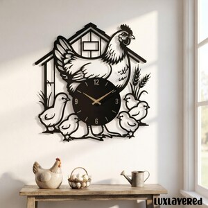 May include: A black metal wall clock featuring a cutout design of a hen standing in front of a coop with four chicks and wheat stalks. The circular clock face is black with gold-colored hands and white numbers at the 3, 6, 9, and 12 positions.