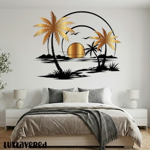 Pu&ograve; includere: Un'opera d'arte da parete raffigurante una scena di tramonto tropicale. Il design include palme dorate, un sole dorato e sagome nere di uccelli e acqua. L'opera &egrave; montata sopra un letto con biancheria da letto dai toni neutri.