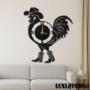 May include: Black wall clock shaped like a rooster wearing a cowboy hat and boots. The clock face is black with white numbers and gold hands. The rooster is a silhouette design, perfect for country-themed decor.