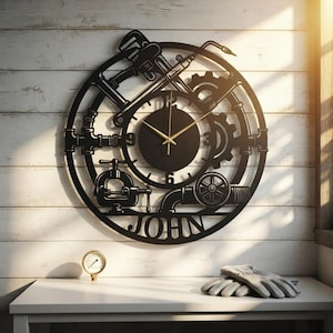 Puede incluir: Un reloj de pared circular negro con un diseño mecánico que incluye herramientas como una llave de tubo, engranajes y una prensa. El centro tiene una esfera negra con manecillas doradas y los números 3, 6, 9 y 12. El nombre JOHN está recortado.