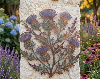 May include: A metal wall art piece featuring a cluster of five thistle flowers with purple-toned heads and green-patina stems and leaves. The sculpture has a rustic, weathered finish and is mounted on a light-colored, textured stone pillar.