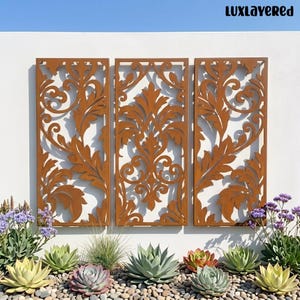 May include: Three rectangular metal wall panels featuring a laser-cut rust-colored finish with intricate scrolling acanthus leaf patterns. The panels are arranged side-by-side, displaying symmetrical organic shapes and cutouts. The text LUXLAYERED is visible in the top right corner.