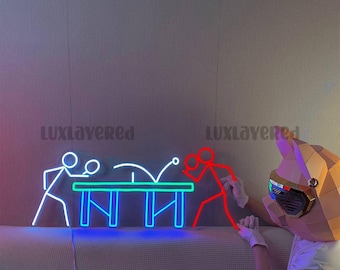 May include: A neon sign featuring a white stick figure playing table tennis against a red stick figure on a green table. The text "LUXLAYERED" appears twice in the background. A person wearing a geometric pig mask and white gloves is visible.