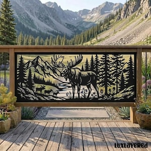 May include: A black metal decorative panel featuring a laser-cut design of a large moose standing in a forest with mountains in the background. The scene includes smaller silhouettes of moose and pine trees, framed by a wooden railing structure.