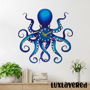 May include: A blue octopus wall clock with gold hands and numbers. The clock is mounted on a white wall. The clock's design features a gradient of blue hues. The word "LUXLAYERED" is printed at the bottom of the image.