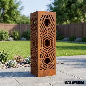 May include: A tall, rectangular, rust-colored metal pillar featuring a laser-cut geometric pattern of interlocking hexagons and lines. The structure has a weathered, oxidized finish and is positioned upright on a gray stone patio surface.