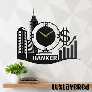 Può includere: Orologio da parete in metallo nero con una silhouette di paesaggio urbano con un quadrante, un simbolo del dollaro e un grafico in crescita. La parola "BANKER" è in basso. Lancette dorate. Arte decorativa da parete.