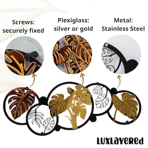 Pu&ograve; includere: Arte da parete decorativa in metallo e plexiglass con disegni di foglie. L'immagine evidenzia i materiali: acciaio inossidabile, plexiglass argento o oro e viti fissate saldamente. Il marchio "LUXLAYERED" &egrave; visualizzato in basso.