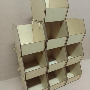 K&ouml;nnte beinhalten: Ein stapelbarer Holz-Organizer mit mehreren F&auml;chern. Der Organizer ist aus hellfarbenem Holz gefertigt und verf&uuml;gt &uuml;ber ein offenes Design f&uuml;r einfachen Zugriff. Die F&auml;cher sind in einem rasterartigen Muster angeordnet, geeignet f&uuml;r kleine Gegenst&auml;nde.