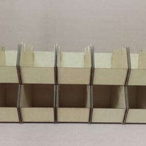 May include: A set of six wooden storage bins, arranged in two rows of three. The bins are constructed from light-colored wood and feature a simple, open-top design. The bins are ideal for organizing small items.