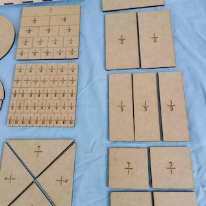 Puede incluir: Un conjunto de manipuladores de fracciones de madera para enseñar conceptos matemáticos. El conjunto incluye una variedad de formas, incluyendo círculos, cuadrados y triángulos, cada uno dividido en diferentes fracciones. Las piezas están etiquetadas con la fracción que representan, como 1/2, 1/3 y 1/4.