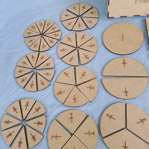 Puede incluir: Un conjunto de círculos de fracciones de madera para enseñar matemáticas. Los círculos están divididos en diferentes fracciones, como 1/2, 1/3, 1/4, 1/5, 1/6, 1/7, 1/8, 1/9, 1/10 y 1/12.