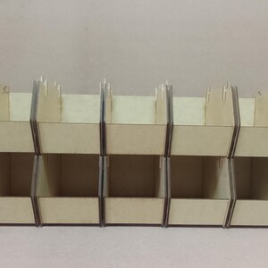 K&ouml;nnte beinhalten: Ein Satz von sechs Holz-Aufbewahrungsboxen, angeordnet in zwei Reihen zu je drei. Die Boxen sind aus hellfarbenem Holz gefertigt und haben ein einfaches, offenes Design. Ideal zum Organisieren kleiner Gegenst&auml;nde.