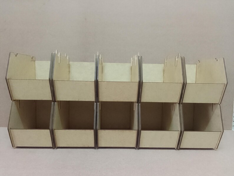 K&ouml;nnte beinhalten: Ein Satz von sechs Holz-Aufbewahrungsboxen, angeordnet in zwei Reihen zu je drei. Die Boxen sind aus hellfarbenem Holz gefertigt und haben ein einfaches, offenes Design. Ideal zum Organisieren kleiner Gegenst&auml;nde.