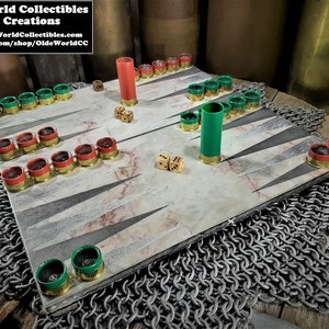 May include: A backgammon board made from wood with a marble-like design. The board is decorated with red and green shotgun shells. The board is sitting on a chainmail surface.