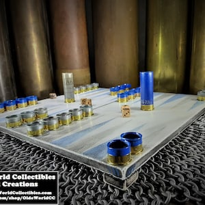 May include: A wooden game board with blue and white stripes. The board is made from repurposed shotgun shells and has a metal frame. The game is set up for play with dice and counters.