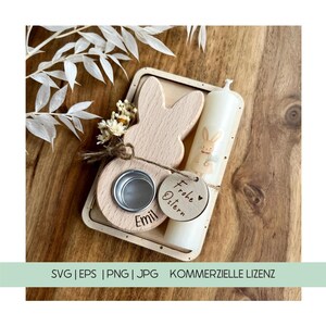 May include: A wooden Easter bunny candle holder with a small round candle holder and a tag that says "Frohe Ostern" with a heart. The candle holder is decorated with a small bunny and the name "Emil".