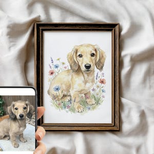 Może przedstawiać: Oprawiony wydruk akwarelowy szczeniaka jamnika długowłosego. Grafika przedstawia psa siedzącego na polu kwiatów polnych w odcieniach niebieskiego, różowego i żółtego. Rama jest w kolorze ciemnobrązowym.