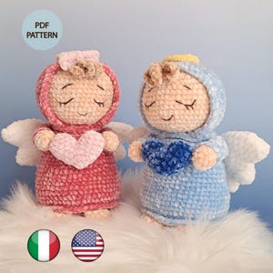 Può includere: Due bambole angelo all'uncinetto fatte a mano, una rosa e l'altra blu, ognuna con un cuore. Hanno ali bianche e indossano abiti con cappuccio. L'immagine include il testo "PDF PATTERN".