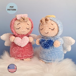 Può includere: Due bambole angelo all'uncinetto fatte a mano, una rosa e l'altra blu, ognuna con un cuore. Hanno gli occhi chiusi, ali e aloni. L'immagine include il testo "PDF PATTERN" e una bandiera americana.