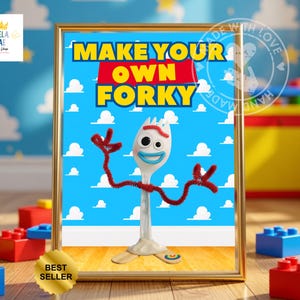 May include: A framed digital print featuring the text MAKE YOUR OWN FORKY in yellow and red letters against a blue background with white clouds. A white plastic spork character with googly eyes, red pipe cleaner arms, and a clay base is centered.