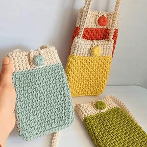 May include: Four crocheted mini bags with different coloured panels and a white strap. The bags have a small button on the front.