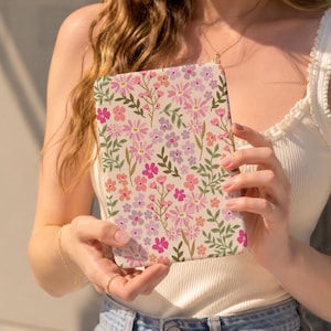 May include: A rectangular e-reader case featuring a cream-coloured background with a repeating pattern of small pink, purple, and orange flowers interspersed with green leafy stems and thin brown branches across the entire surface.