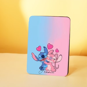 May include: A rectangular case with a blue and pink gradient. It features a cartoon illustration of two characters hugging, with hearts around them. The word "Jennia" is written in cursive at the bottom.