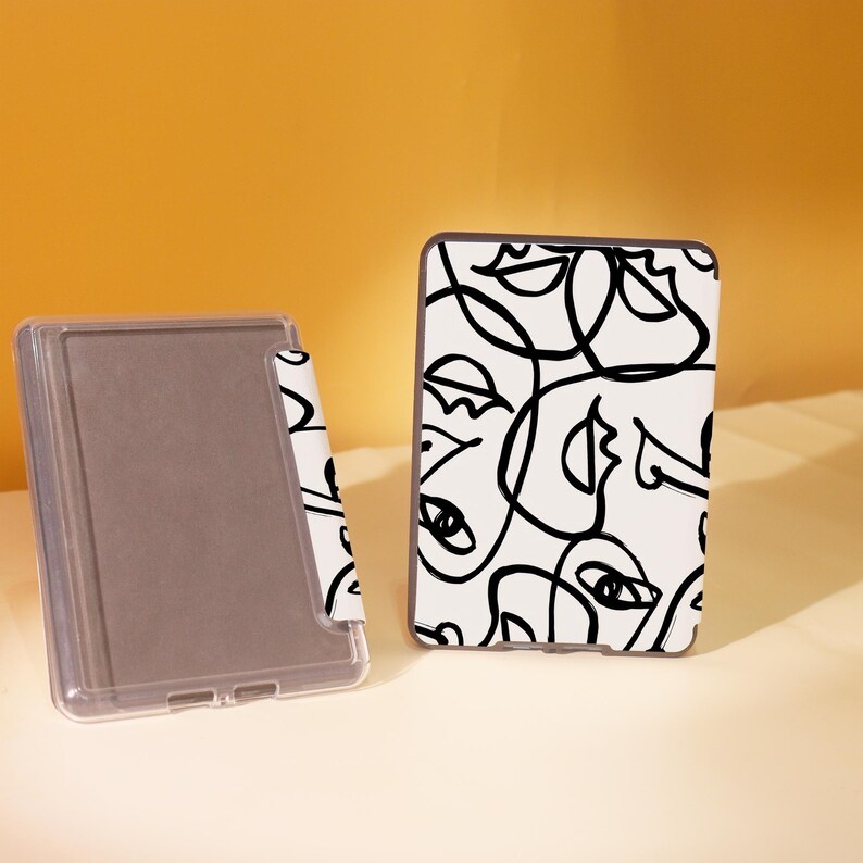May include: Two Kindle e-reader cases, one with a black and white abstract design and the other with a plain gray cover.