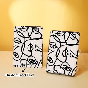 May include: Two black and white e-reader covers with an abstract design of faces. The design is made up of black lines on a white background. The text "Friday" is visible on the left cover.