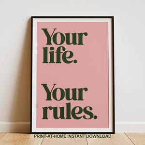 May include: A printable poster with a pink background and black text that reads "Your life. Your rules." The poster is framed in a black frame.