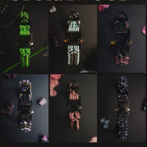 May include: Six paracord bracelets with black metal clasps are displayed. The bracelets showcase diverse colour combinations, such as green, blue, pink, purple, and black and white. The text "STORMWOOD COLLECTION" is visible at the top and bottom.