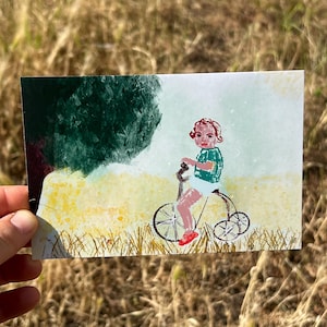 Cartolina in stile vintage - Bambino su triciclo in un prato. Cartolina nostalgica con triciclo. Cartolina vecchio stile nel campo.