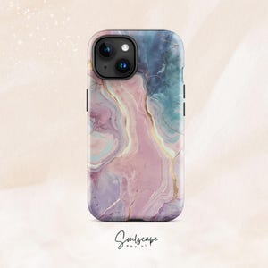 May include: A phone case with a marble design in shades of pink, purple, and blue, accented with gold veins. The case has a glossy finish and features a camera cutout. The word "Soulscape" is written in cursive at the bottom.