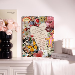Könnte beinhalten: Eine rechteckige Tablethülle mit einer lebendigen Collage aus weißen Lilien, einem Monarchfalter, einem roten Herzen, einem Sonnensymbol und einer Kaffeetasse. In der Mitte befindet sich eine herzförmige Notiz mit dem spanischen Text: SIGUE ADELANTE. Tu vida será buena, porque tú eres BUENA. TU VIDA ESTARÁ llena de amor, porque tú estás llena de AMOR. VAS A SANAR, solo sigue ADELANTE.