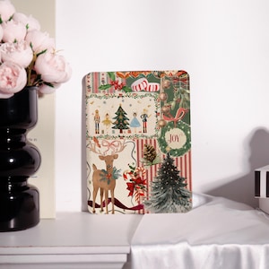 May include: A rectangular Christmas-themed decorative item with a collage of festive illustrations. The design includes a deer, Christmas trees, nutcrackers, candy canes, and the word "JOY" in a wreath. The color palette features red, green, and gold accents.