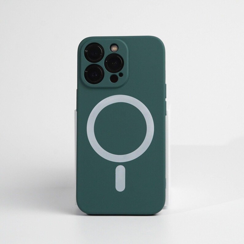 May include: A teal green phone case with a white circle and a white vertical line in the center. The case has a raised camera bump with three black camera lenses.