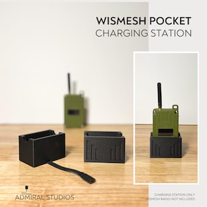 May include: A black WISMESH POCKET CHARGING STATION with vertical line cutouts. The set includes two rectangular charging docks, one with an attached black cable. An olive green radio with an antenna is shown docked in the station.