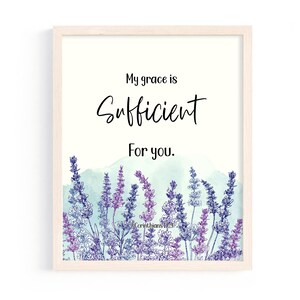 May include: Framed art print featuring the text "My grace is Sufficient For you." in black script. The artwork includes a watercolor wash of blue-green and a border of purple and blue lavender flowers. The scripture reference "Corinthians 12:9" is at the bottom.
