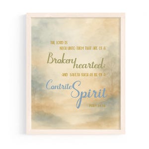 May include: A framed print with a watercolor background in shades of blue, beige, and brown. The text reads "THE LORD IS NIGH UNTO THEM THAT ARE OF A Brokenhearted: AND SAVETH SUCH AS BE OF A Contrite Spirit PSALM 34:18."