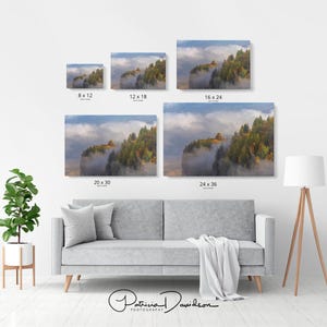 Puede incluir: Se exhiben varias impresiones en lienzo de paisajes en una pared blanca. Las impresiones muestran una escena monta&ntilde;osa con niebla, &aacute;rboles y un edificio. Tama&ntilde;os: 8x12, 12x18, 16x24, 20x30 y 24x36 pulgadas (aprox. 20x30, 30x46, 41x61, 51x76, y 61x91 cm). Firma del artista.