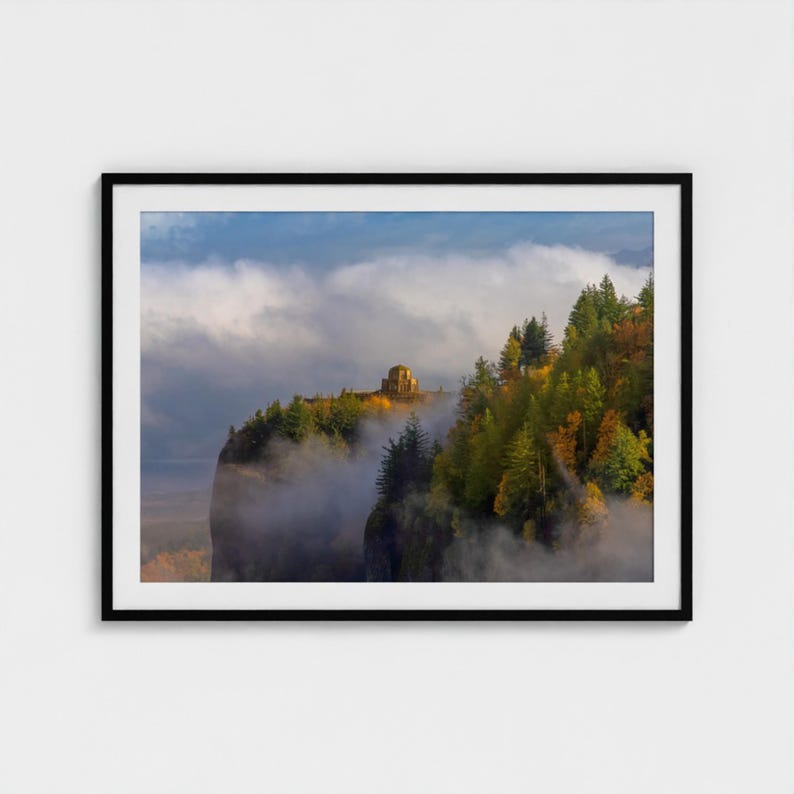 Puede incluir: Fotograf&iacute;a enmarcada de un paisaje de acantilado con una estructura de piedra en la cima, rodeada de &aacute;rboles con colores oto&ntilde;ales. La escena est&aacute; parcialmente oscurecida por la niebla, con un cielo nublado.