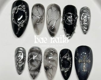 Uñas postizas de cromo negro, estilo gótico con cruz oscura.