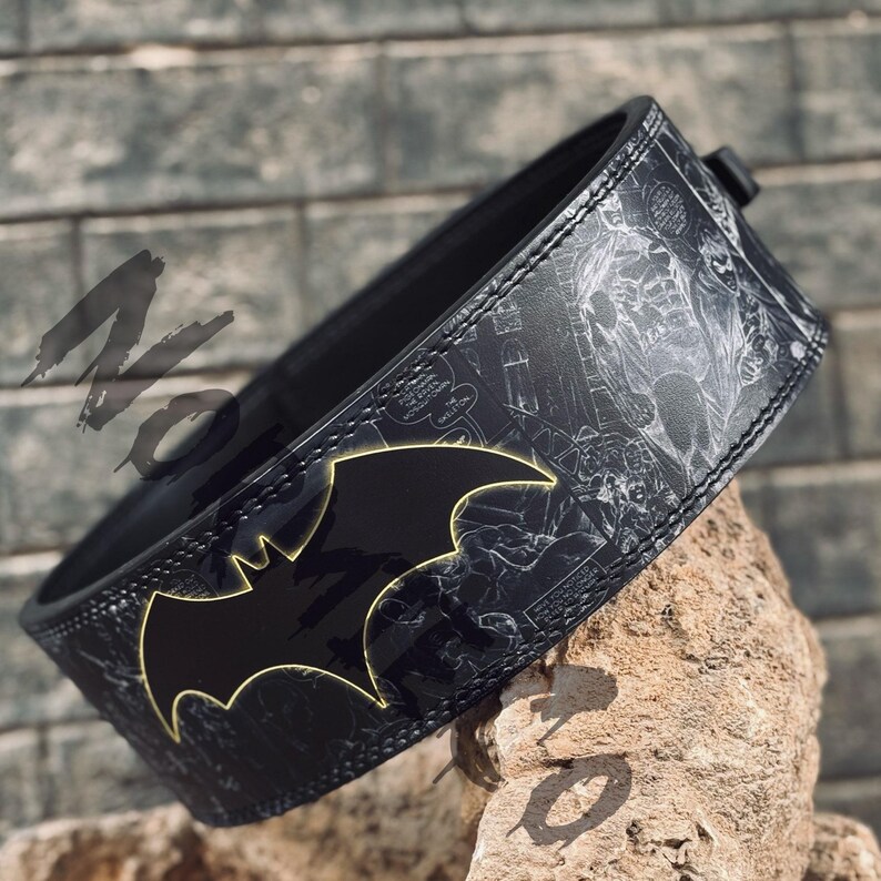 Peut inclure: Ceinture d'halt&eacute;rophilie noire avec un logo Batman noir brillant et un contour jaune. La ceinture pr&eacute;sente un motif de bande dessin&eacute;e et est fabriqu&eacute;e dans un mat&eacute;riau durable. Con&ccedil;ue pour l'halt&eacute;rophilie et la musculation.