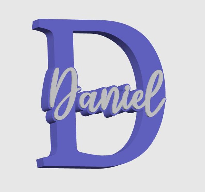May include: A 3D-rendered, periwinkle-colored letter "D" with the name "Daniel" in a cursive, light gray font overlaid on the letter. The design has a slight shadow effect, giving it a three-dimensional appearance. The background is a plain, light gray.