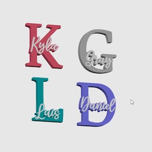 May include: Four 3D-printed letters: K, G, L, and D. Each letter has a name written across it in a cursive font. The letters are in shades of red, gray, teal, and purple. The names are Kyla, Gray, Luis, and Daniel.