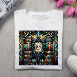 Könnte beinhalten: Weißes T-Shirt mit einer bunten Grafik einer Bücherregals voller Bücher. Die Grafik hat einen dekorativen Rahmen und den Text "Just One More Chapter".